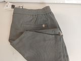 grey pants hanging on a wall with a white board in the background