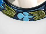 a close up of a mirror with a flower design on it