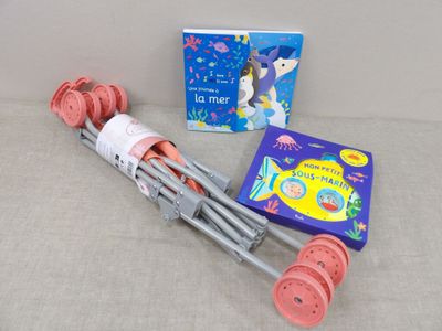 a pink crutt with wheels and a book next to it