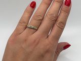 the woman ' s hand is holding a red manicure and a gold ring
