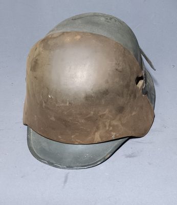an old helmet sitting on top of a table on a white surface