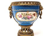 a blue vase with flowers on it sitting on a stand