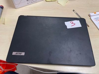 a laptop computer sitting on a desk next to a pen and paper