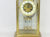 a gold clock that is sitting on a white surface