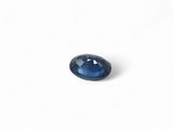 a close up of a blue sapphire stone on a white surface