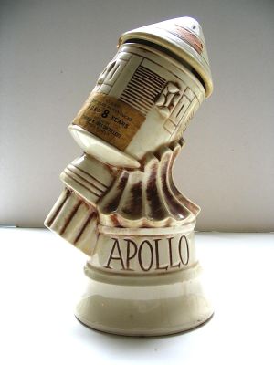 une petite statue représentant un robot tenant une canette d'Apollo