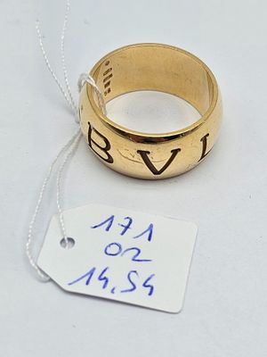a gold ring with a name on it next to a price tag