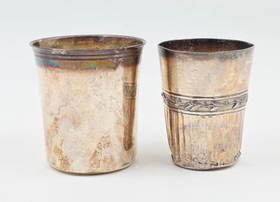 deux tasses en argent posées l'une à côté de l'autre sur une surface blanche