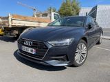 a grey audi car parked in a parking lot next to a truck