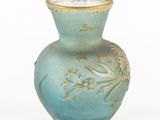 a blue vase with gold decoration on it on a white surface