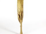 a gold feather that is sitting on top of a table