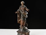 an old statue of a woman holding a basket on top of a table
