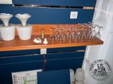 bottles and glasses on a shelf in a room with a blue wall