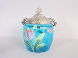 un vase bleu orné de fleurs peintes et muni d'un couvercle en argent