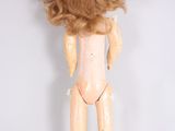 an image of a doll that is standing up on a white surface
