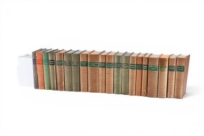 une rangée de livres empilés les uns sur les autres sur une surface blanche