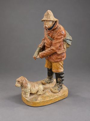 figurine of a man with a dog on a wooden base