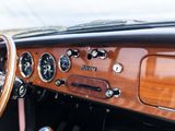 a dashboard of a classic car with a wooden steering wheel