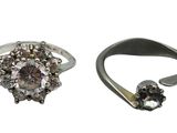 two silver rings with diamonds on them and one with a flower