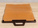 brown leather ipad case on a wooden table with a brown handle
