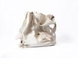a white purse that is sitting on a white surface