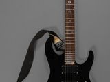 une guitare électrique à laquelle est accrochée une sangle au niveau du manche