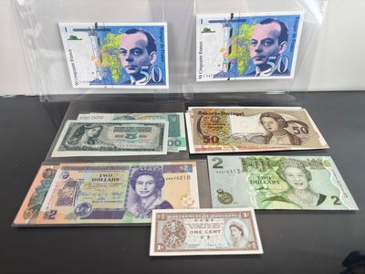 several different bank notes are on display in a clear case