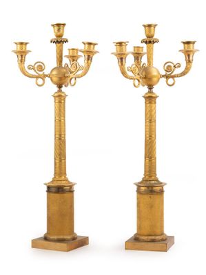 une paire de chandeliers anciens en laiton sur socles, sur fond blanc
