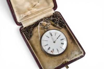 une boîte contenant une horloge, posée sur une surface blanche