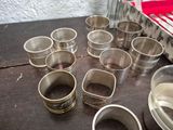 a lot of silver cups sitting on a wooden table