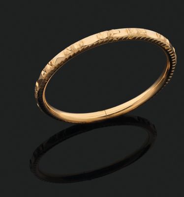 a gold bangle with a textured design on it