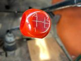 a close up of a red knob on a green car