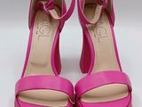 a close up of a pair of pink shoes on a white surface