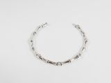 gros plan d'un bracelet en argent sur une surface blanche