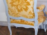 a yellow and blue chair sitting on a parquet floor