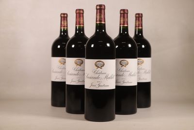 trois bouteilles de vin rouge sont alignées sur une table
