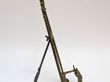 brass giraffe sculpture on a stand on a white background