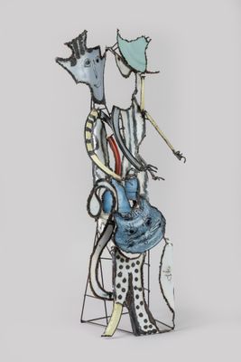 a sculpture of a man sitting on a chair with a cat on his back