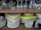 de nombreuses assiettes et verres sur une étagère dans la cuisine