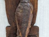 a wooden sculpture of a bird on a stand