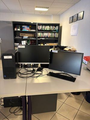 a desk with two monitors and a keyboard on it