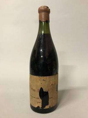 une bouteille de vin posée sur une table blanche