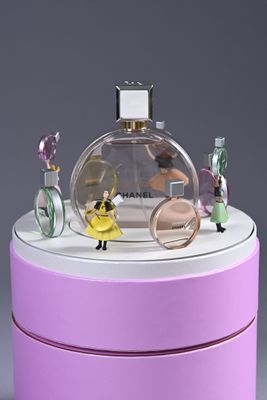 a bottle of perfume sitting on top of a pink box