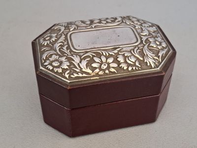 a small wooden box with a metal lid on a table
