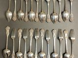 a lot of silver spoons and forks on a table