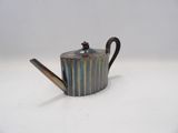a silver teapot with a handle on a white surface