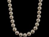 un collier de perles blanches sur fond noir