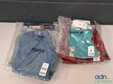 deux t-shirts emballés dans des sacs en plastique, posés sur une table