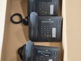 deux téléphones noirs dans une boîte en carton posée par terre
