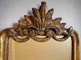a mirror with a gold frame on the wall